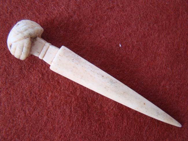A 19th century carved whalebone BODKIN with turks' head knot end
